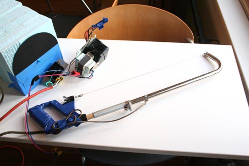 Wire foam-cutter kludged together from a hack-saw, dimmer, dowels, and an old transformer. Make sure you tape up the handle or you'll get zapped!