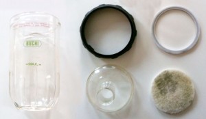 The beaker taken apart. In the lower right is an anti-boil-over Scotchbrite pad (it is stained with mint).